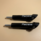 Black Pintryx drop set pins laying flat on beige background.