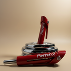 Red Pintryx drop set pins in middle of  weight plate on beige background.